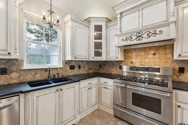 a kitchen with stainless steel appliances white cabinets and a stove