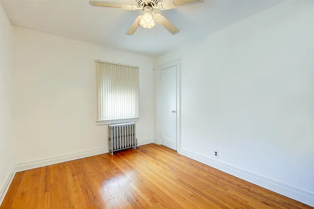 an empty room with a window and wooden floor