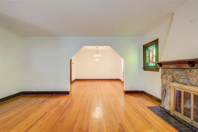 a view of empty room with wooden floor and fireplace
