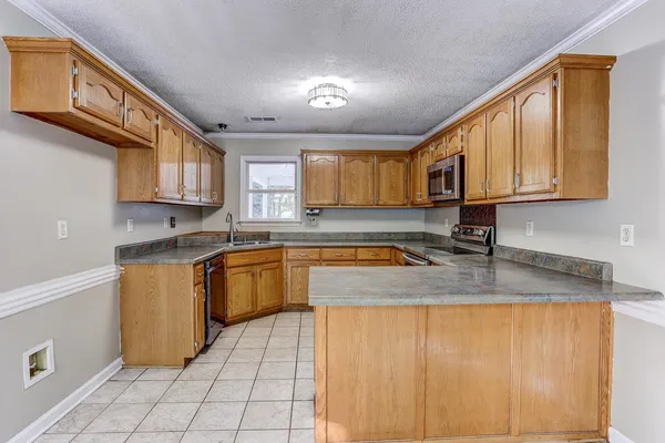 a kitchen with stainless steel appliances granite countertop a sink stove and cabinets