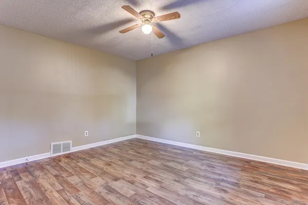 a view of an empty room with wooden floor