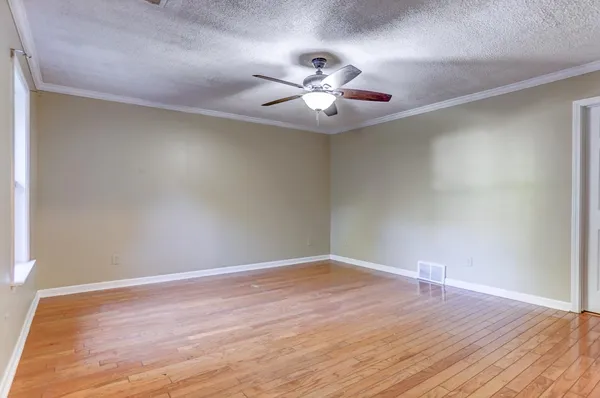 a view of an empty room with wooden floor