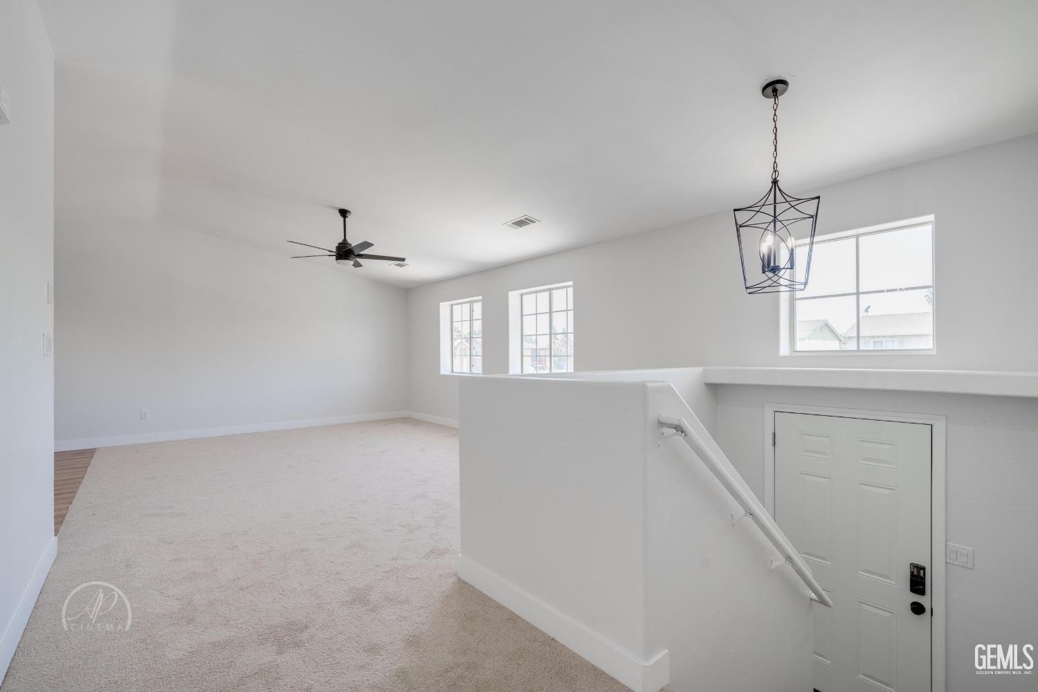 Undisclosed Address Bakersfield, CA 93307 - Photo 3 of 14 an empty room with windows and chandelier