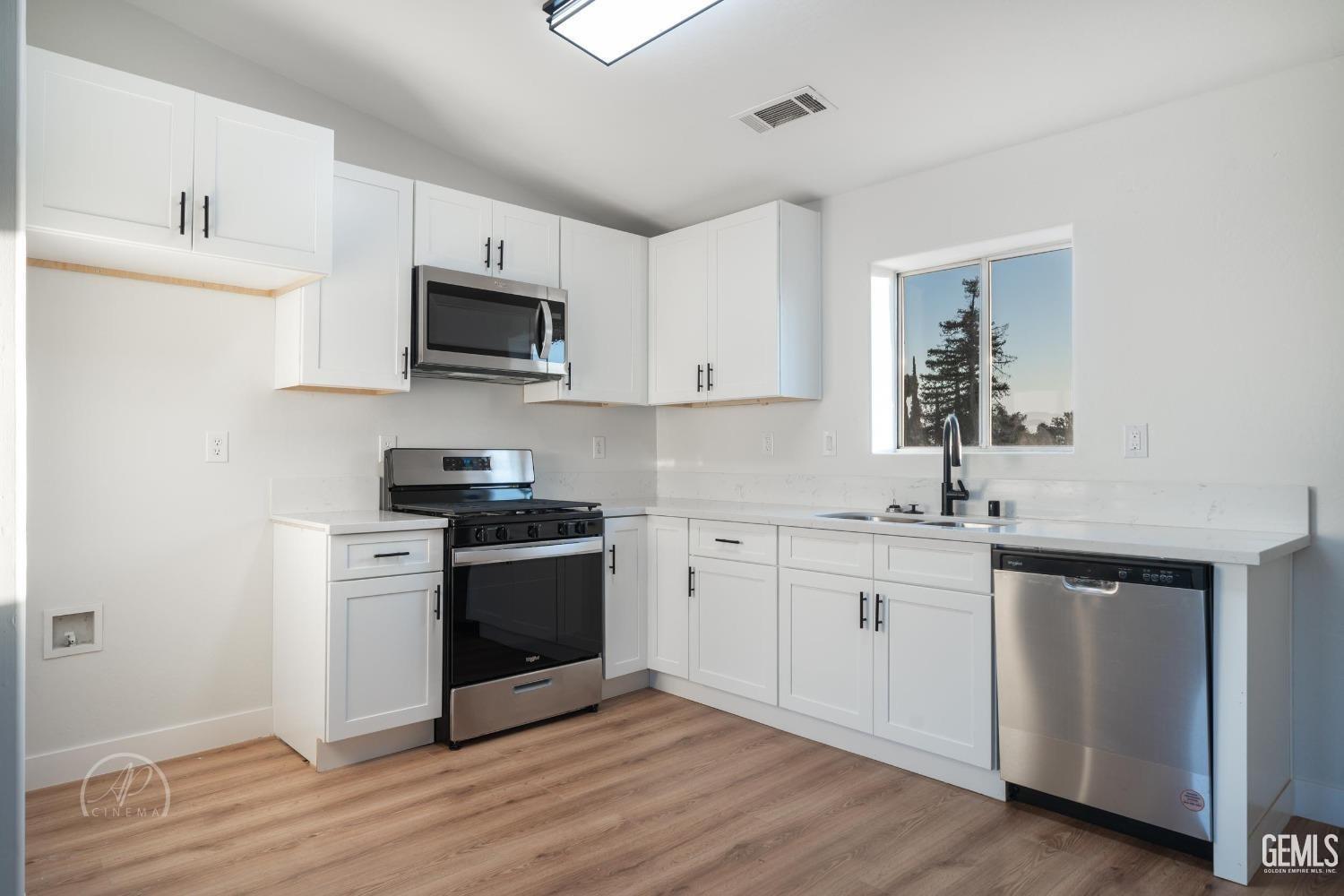 Undisclosed Address Bakersfield, CA 93307 - Photo 5 of 14 a kitchen with stainless steel appliances granite countertop a stove a sink and a microwave
