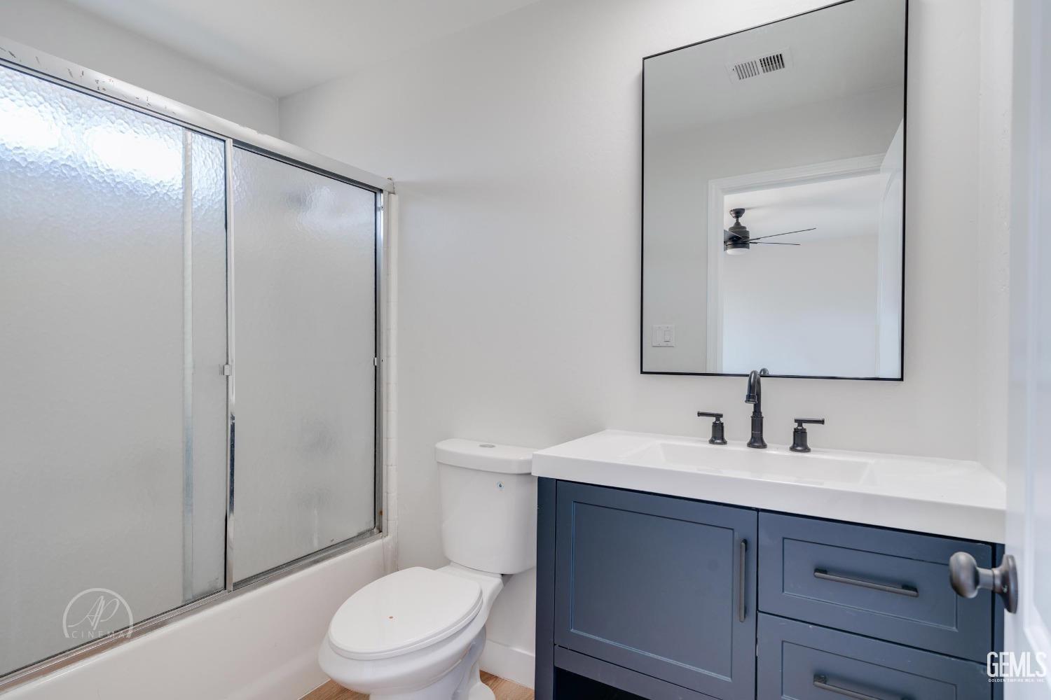 Undisclosed Address Bakersfield, CA 93307 - Photo 6 of 14 a bathroom with a sink a toilet a mirror and shower