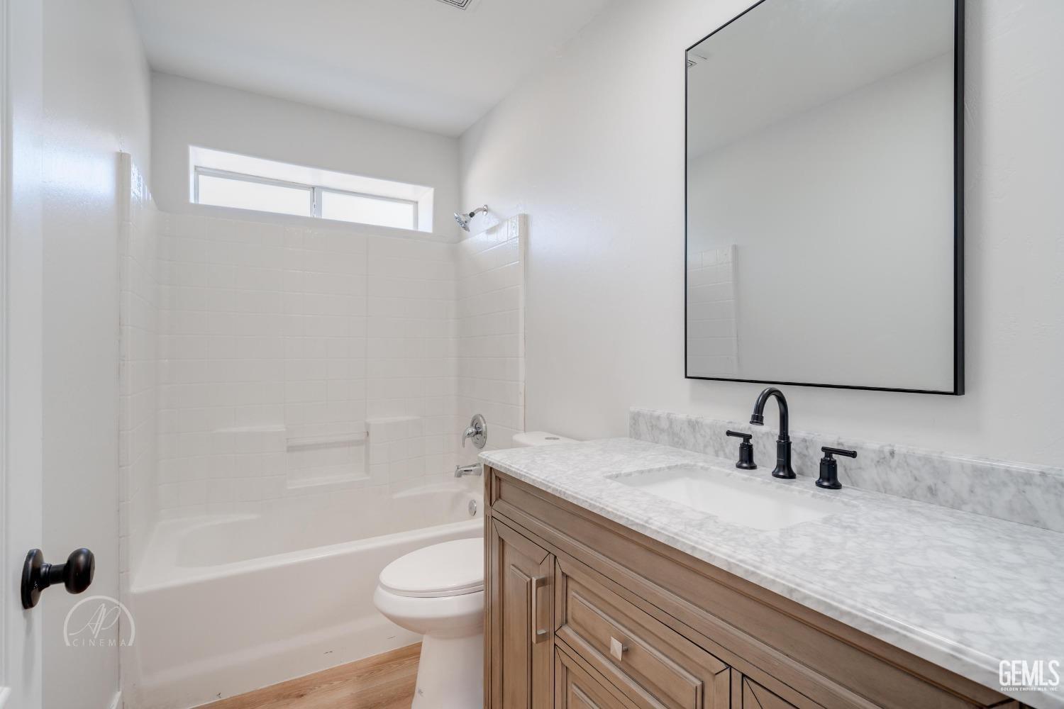 Undisclosed Address Bakersfield, CA 93307 - Photo 10 of 14 a bathroom with a granite countertop sink toilet and shower