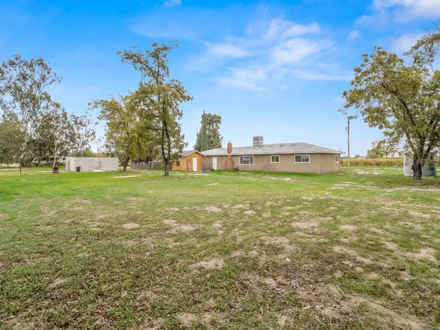 a backyard of a house with table and chairs