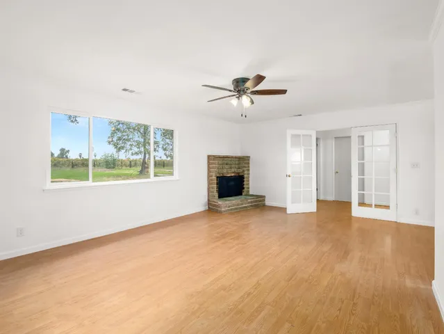 a view of an empty room with a window and fireplace
