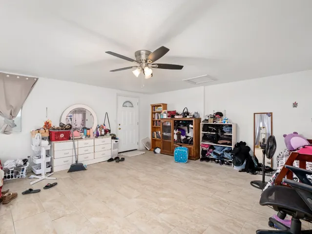an empty room with a ceiling fan and a rug
