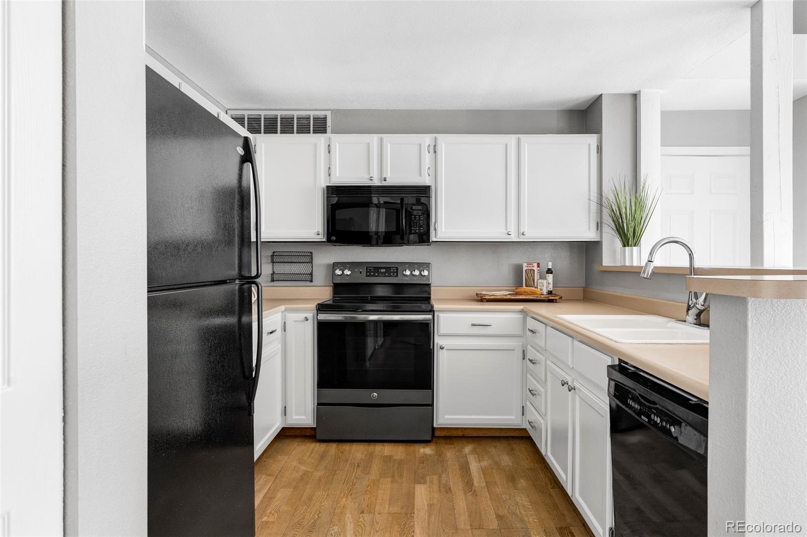 862 South Reed Court, Unit J Lakewood, CO 80226 - Photo 11 of 37 a kitchen with a refrigerator stove and sink