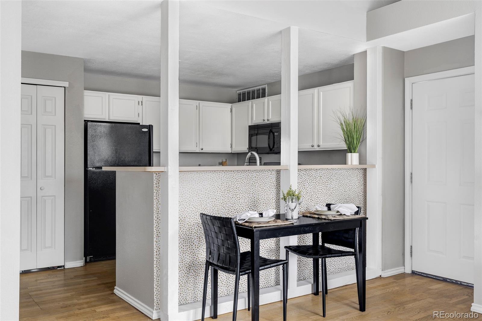 862 South Reed Court, Unit J Lakewood, CO 80226 - Photo 10 of 37 a kitchen with stainless steel appliances a dining table chairs microwave and refrigerator