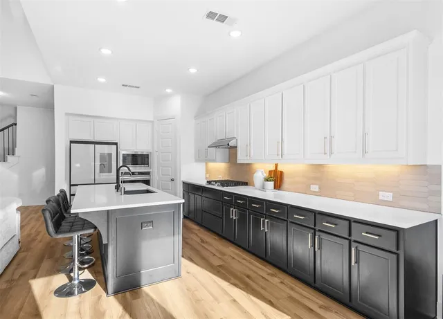 a kitchen with a sink appliances and cabinets