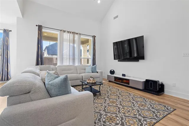 a living room with furniture and wooden floor