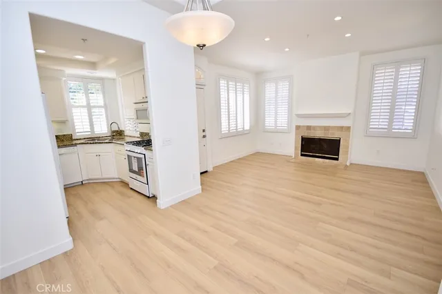 a view of a kitchen with a stove wooden cabinets and wooden floor