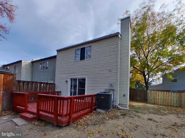 a view of a house with wooden deck and furniture