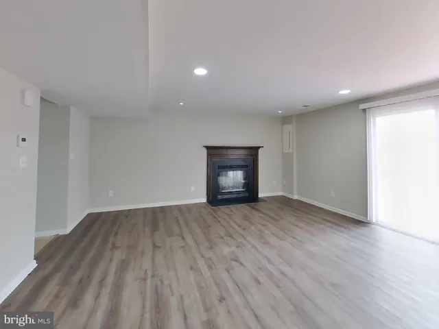 a view of an empty room with wooden floor and closet