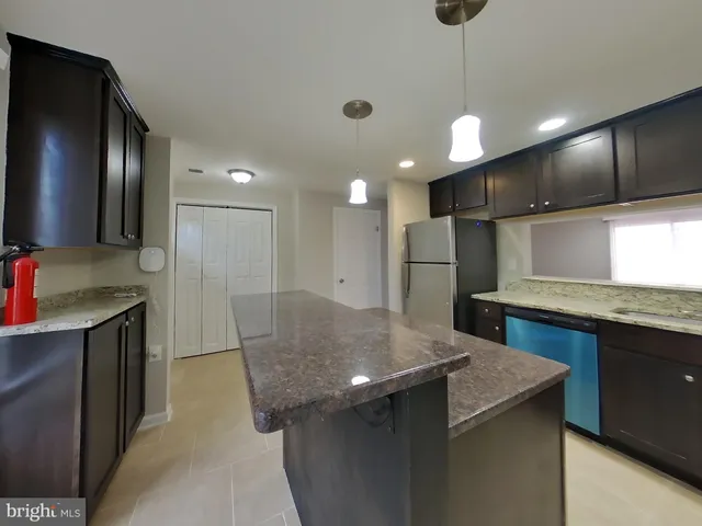 a kitchen with stainless steel appliances granite countertop a sink a refrigerator and a stove