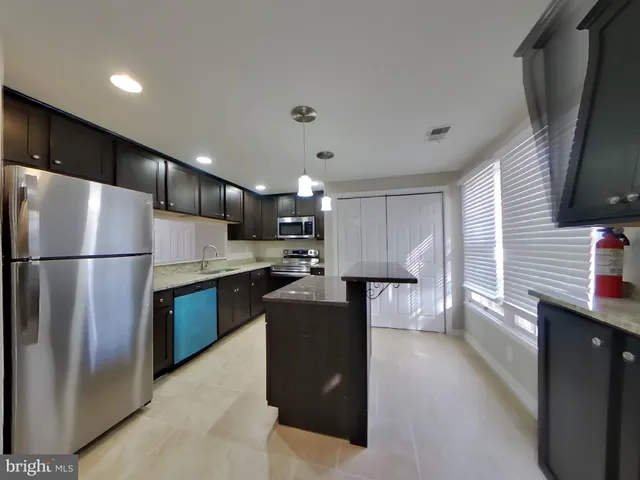 a kitchen with refrigerator and cabinets
