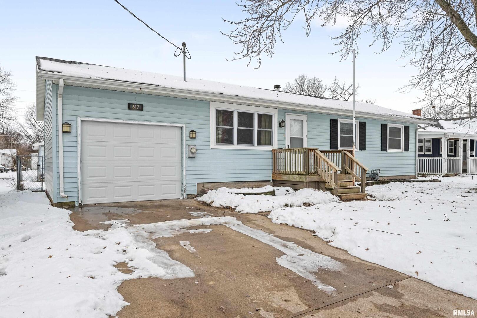 617 6th Street Camanche, IA 52730 - Photo 2 of 25 a front view of a house with a yard covered in snow