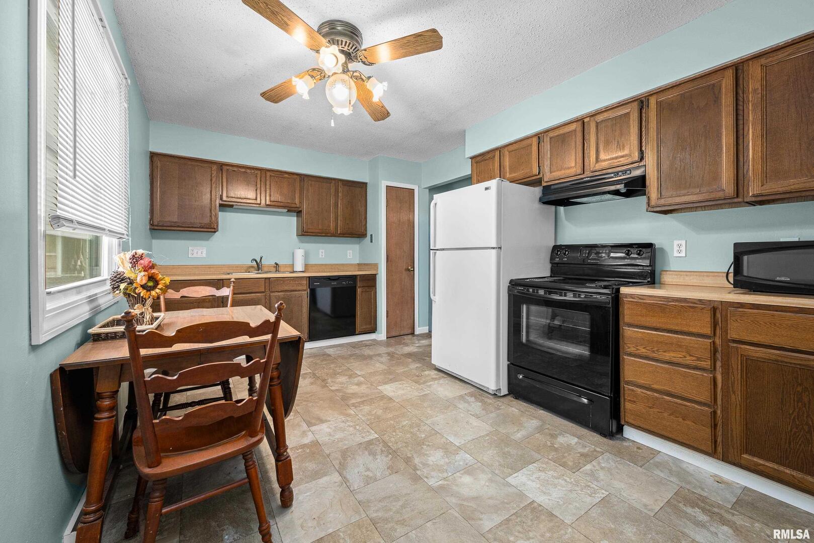 617 6th Street Camanche, IA 52730 - Photo 6 of 25 a kitchen with stainless steel appliances granite countertop a stove a sink dishwasher and a refrigerator