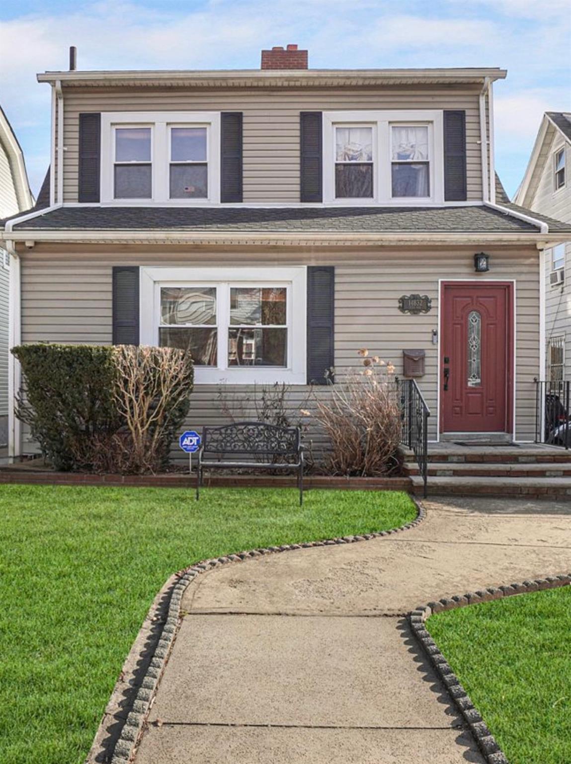 View of front facade with a front yard and a chimney