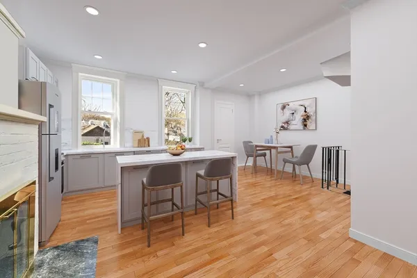 a dining room with furniture a rug and kitchen view