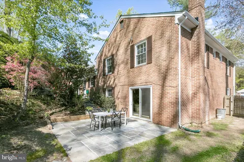 a view of house with backyard and sitting area