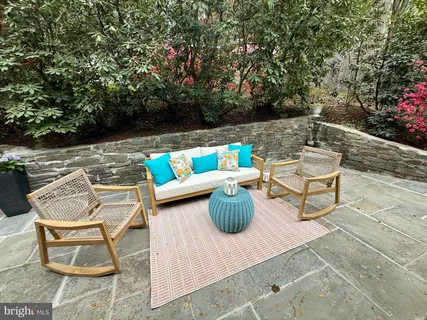 a patio with a table and chairs and potted plants