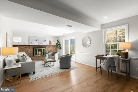 a living room with fireplace furniture and a large window