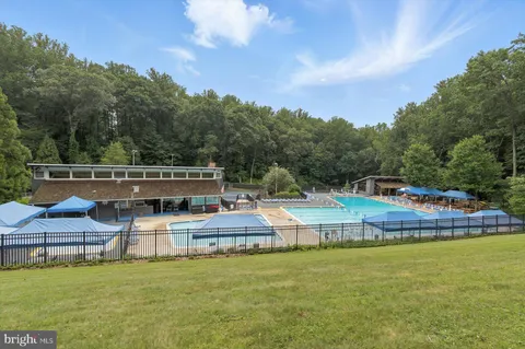 a view of a house with pool and chairs