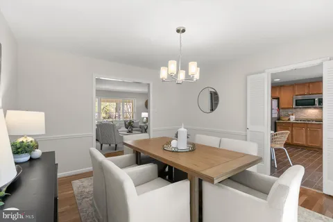 a view of a dining room with furniture a chandelier and wooden floor