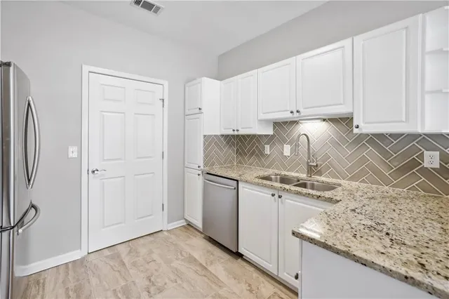 a kitchen with granite countertop white cabinets and white appliances