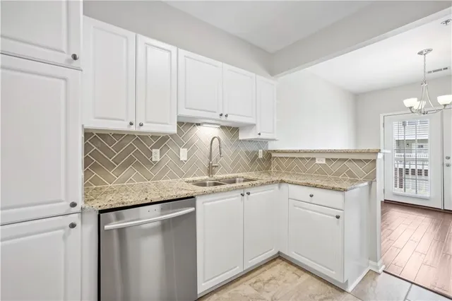 an empty room with wooden floor chandelier fan and windows