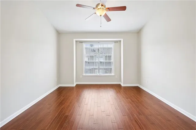 an empty room with wooden floor chandelier fan and closet in a room