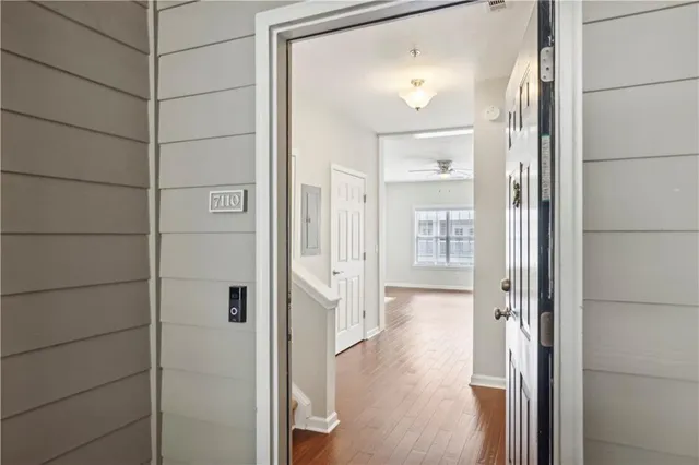 a view of a hallway with wooden floor and stairs