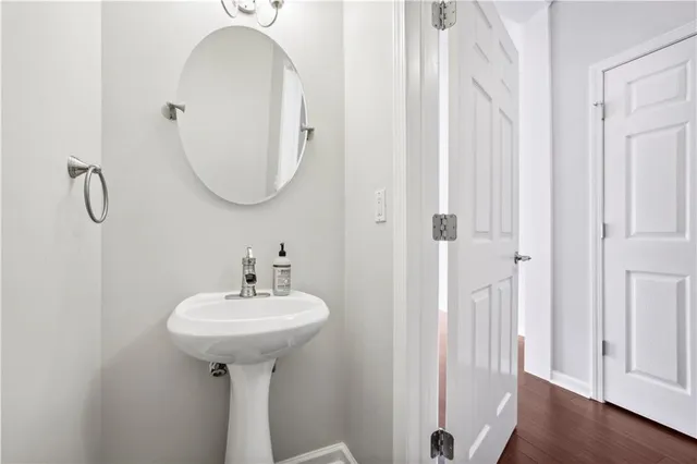 a view of an empty room with wooden floor fridge and a window