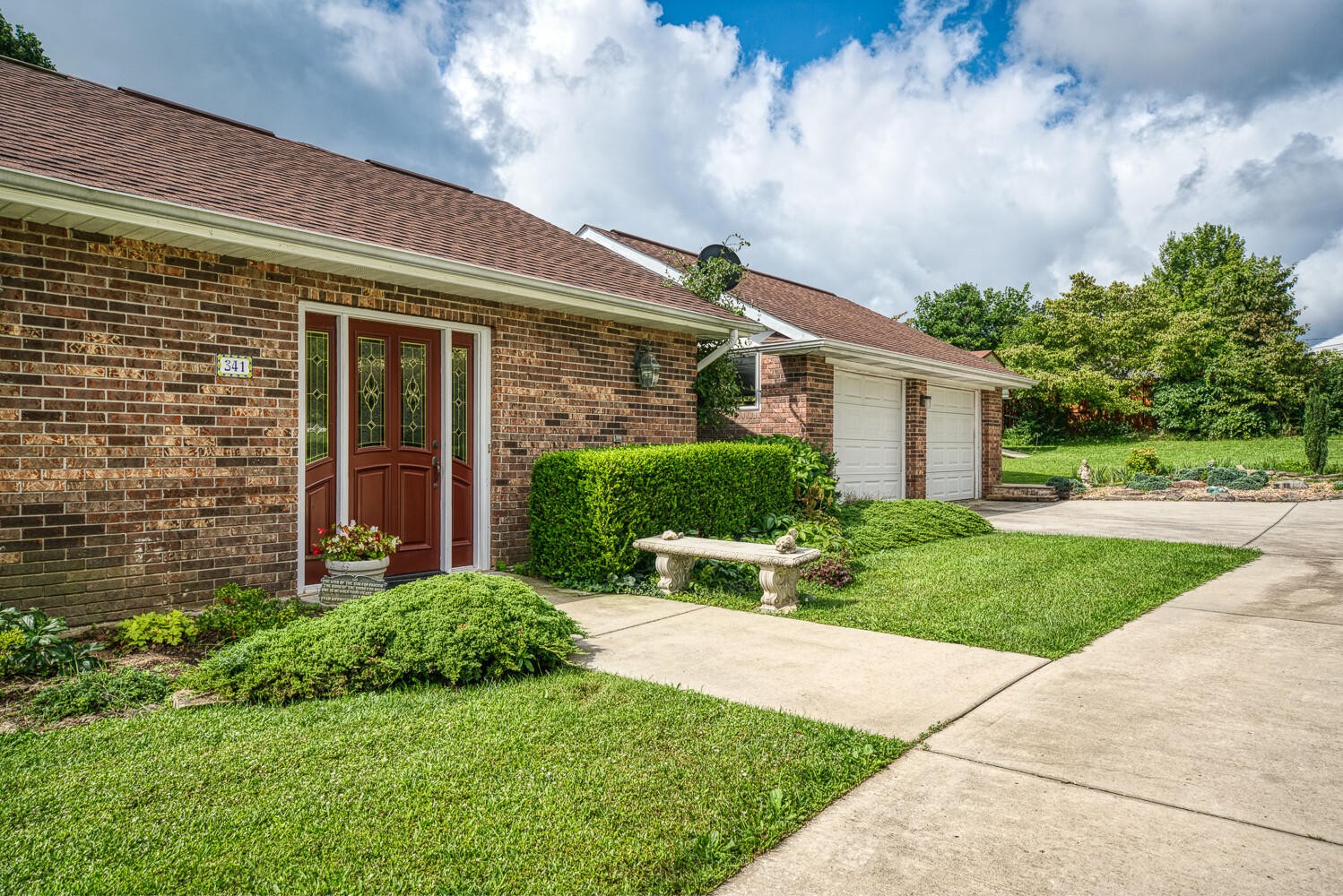 341 Roma Drive Crossville, TN 38555 - Photo 6 of 33 a view of a house with brick walls plants and large tree