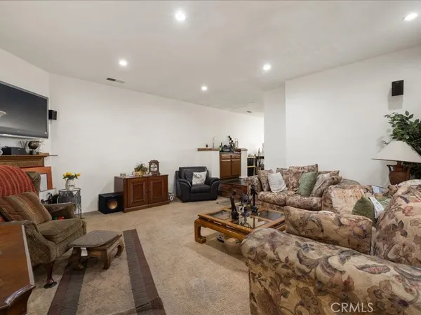 a living room with furniture a flat screen tv and a large window