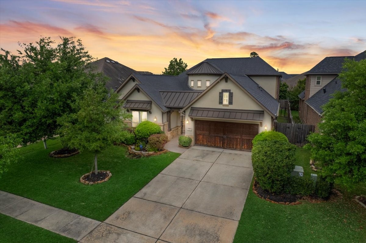 Welcome Home! Striking front elevation featuring a beautiful stucco exterior, accented by elegant metal roofing and a decorative garage.