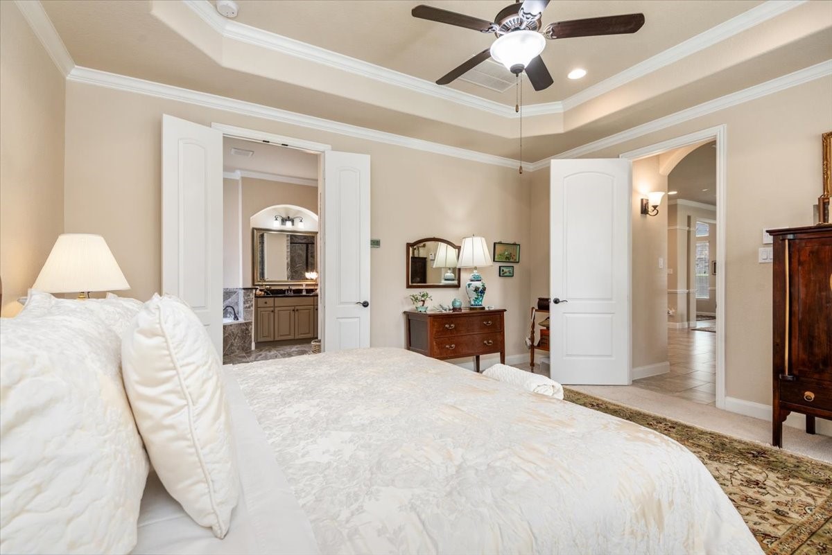 3771 Pinebrook Hollow Lane Spring, TX 77386 - Photo 19 of 50 a large bedroom with a bed and a chandelier