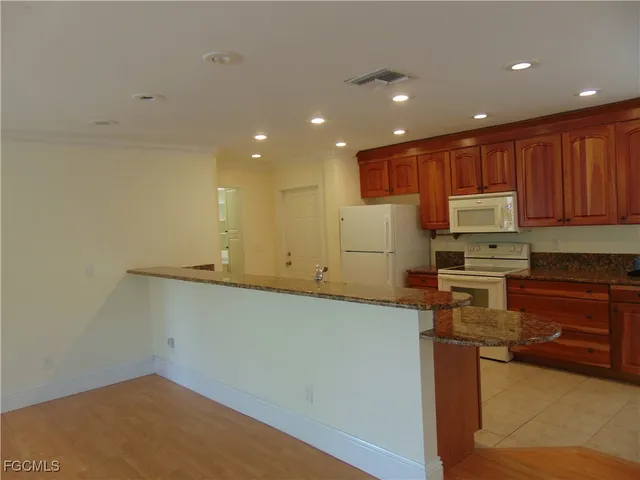 a kitchen with a refrigerator and a stove top oven