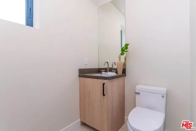 a bathroom with a toilet a sink and a mirror