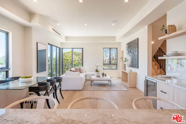 a living room with furniture large window and wooden floor