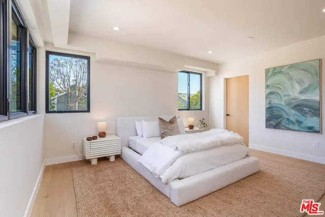 a bedroom with bed and a painting on the wall