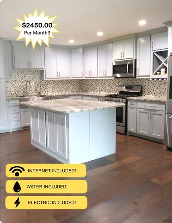 a kitchen with kitchen island granite countertop a stove a sink and a microwave