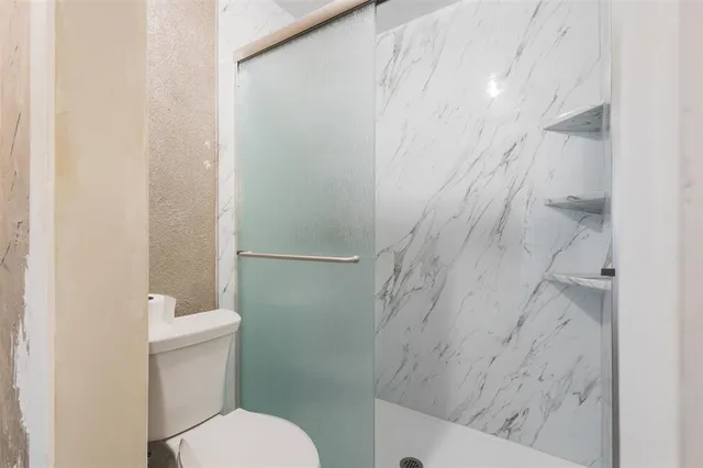 a bathroom with a toilet and a shower