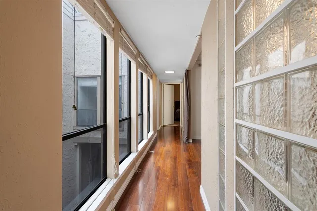 a view of a hallway with wooden floor and staircase