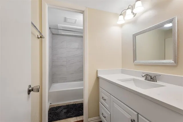 a bathroom with a sink a shower a mirror and a bathtub