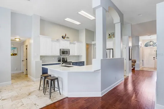 a bedroom with a bed a dresser and a chandelier