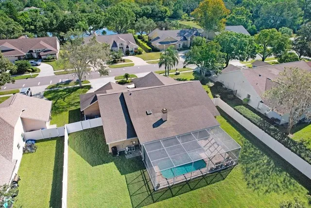 an aerial view of residential houses with outdoor space and trees